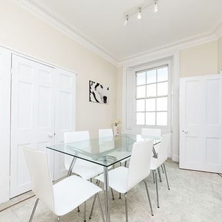 white dining room with glass table