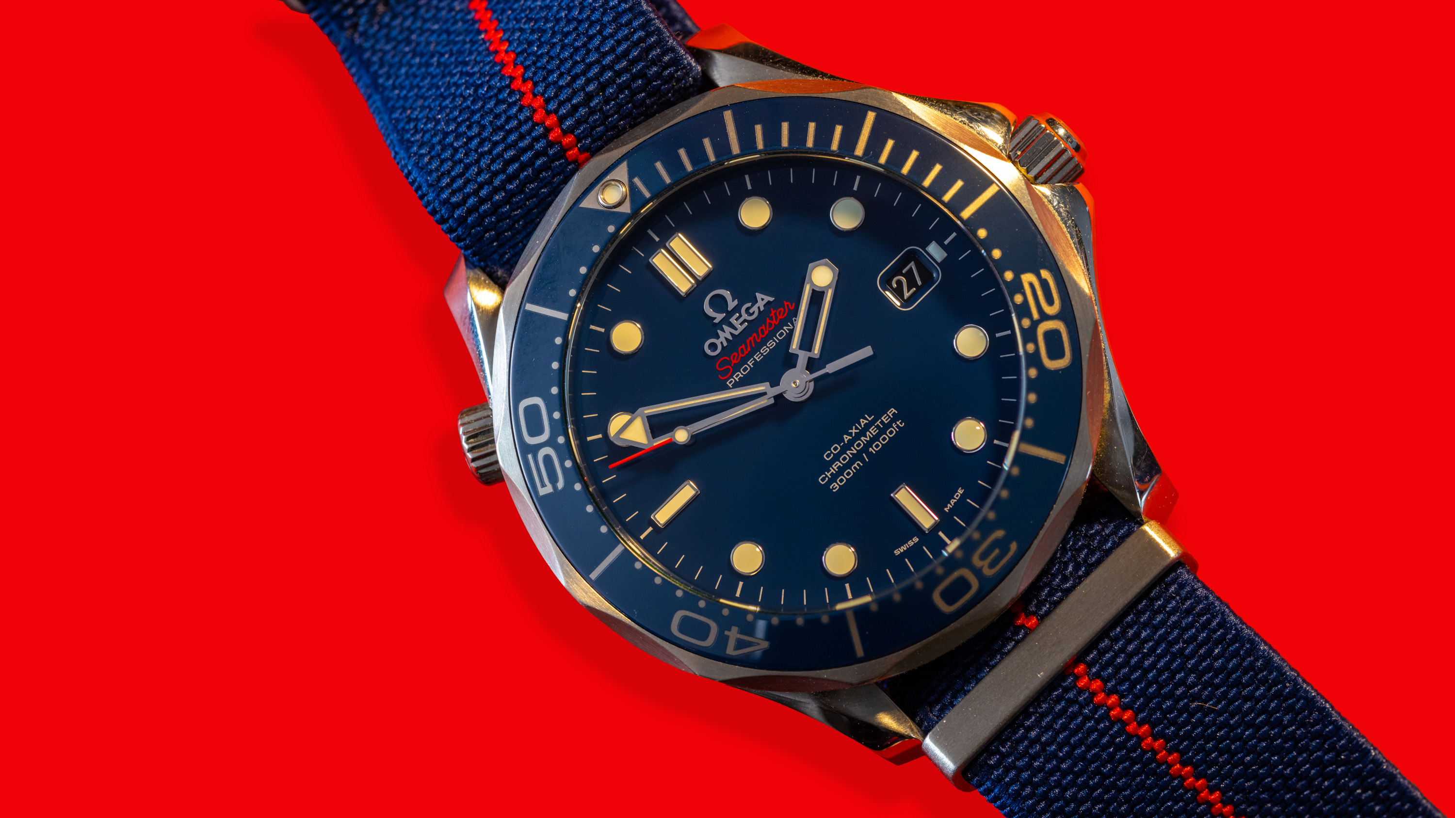 A blue Omega Speedmaster on a red background