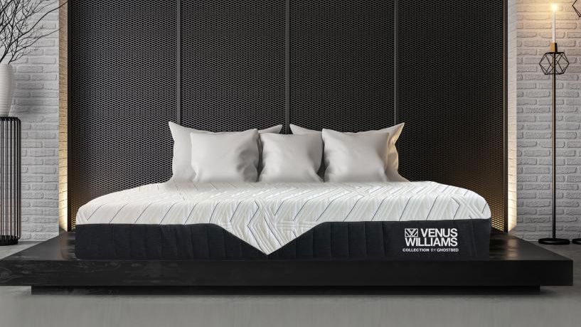 The Venus Williams Legend Mattress Hybrid placed on a black gloss platform in a white brick bedroom