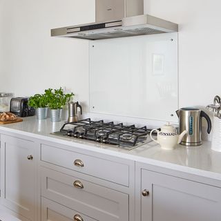 gey shaker kitchen with gas hob chimney and drawer cabinet