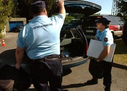 Case closed: Gendarmes pack up, taking Cristian Moreni (Cofidis) with them.