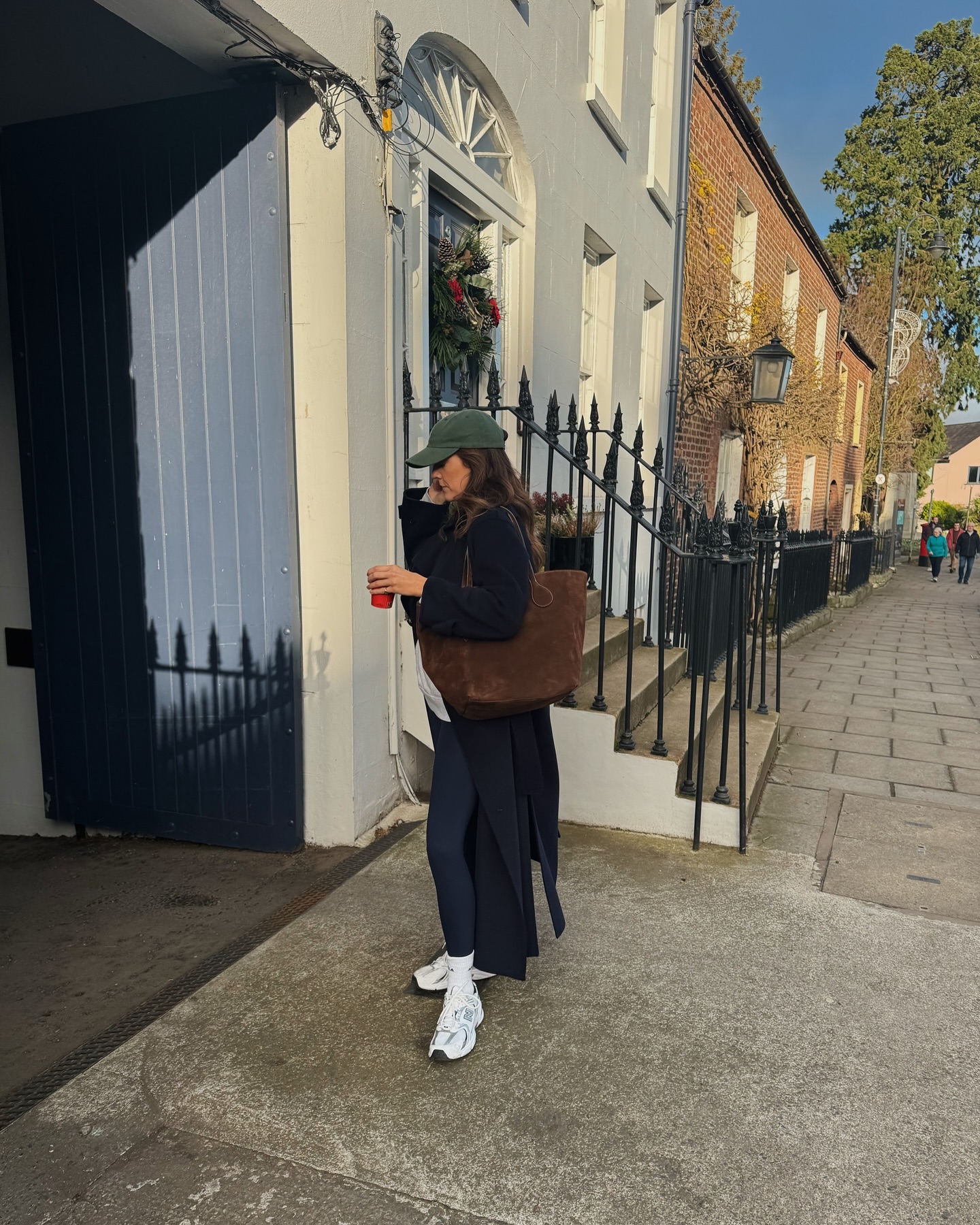 Leggings outfits 2025: @kimturkington wears leggings with a long coat and trainers