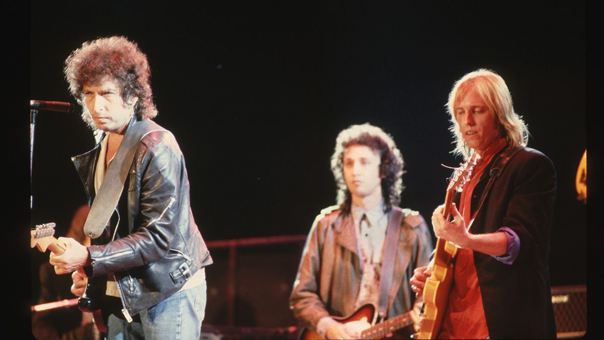 Bob Dylan on stage with Tom Petty and the Heartbreakers. Mike Campbell, Heartbreakers&#039; guitarist, is in the background