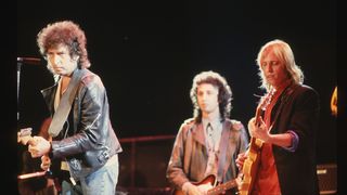 Bob Dylan on stage with Tom Petty and the Heartbreakers. Mike Campbell, Heartbreakers' guitarist, is in the background