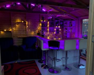 shed bar lit with brightly coloured neon lighting