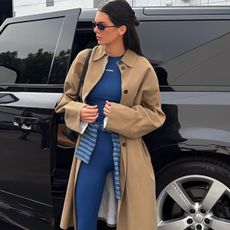 Kendall Jenner wearing a khaki car coat with royal blue Adanola leggings and a matching bra top.