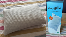 The Cloudpillo Original cooling pillow pictured in its box and on a bed, featuring pastel-coloured stripy bedding.