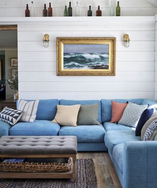 Living room with blue modular sofa and colorful cushions in Cornish coastal newbuild