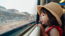 Little girl looking out of the window on a train