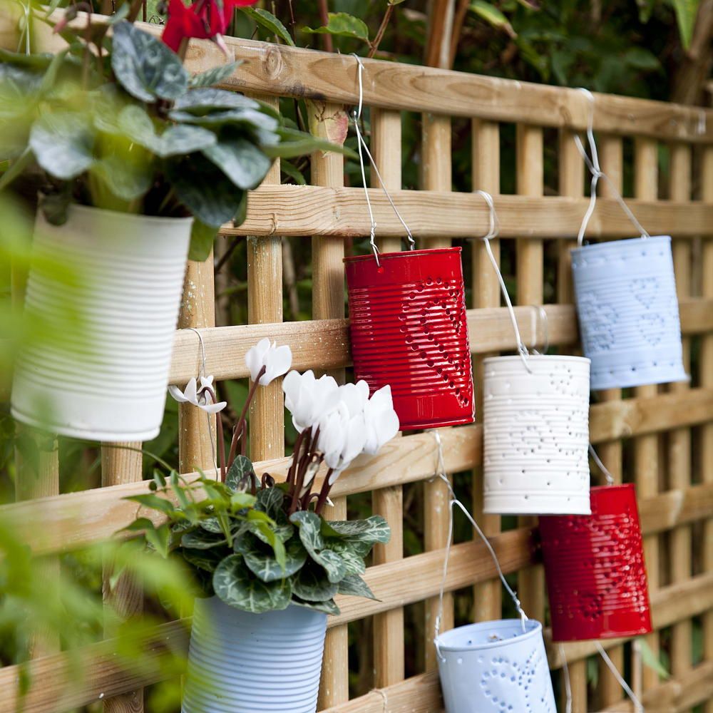 garden with wooden fence suspended planters and white flowering plant