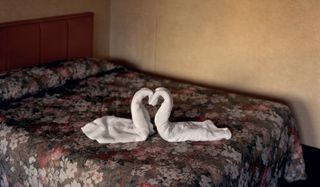 photograph of bed with shaped white towel