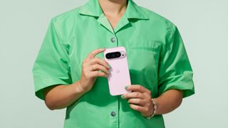 Press shot of a woman in green shirt holding a Google Pixel 9