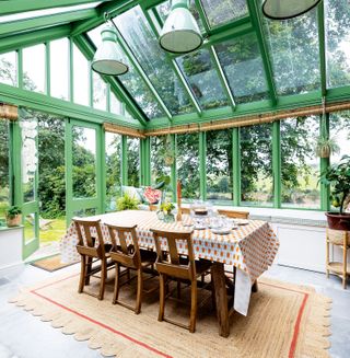 conservatory with green painted window frames and dining table