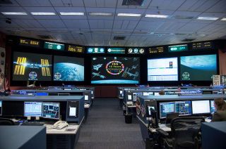 View inside the space station flight control room at NASA's Johnson Space Center in Houston. Displayed on the front screen, images celebrating the International Space Station's 15 years.