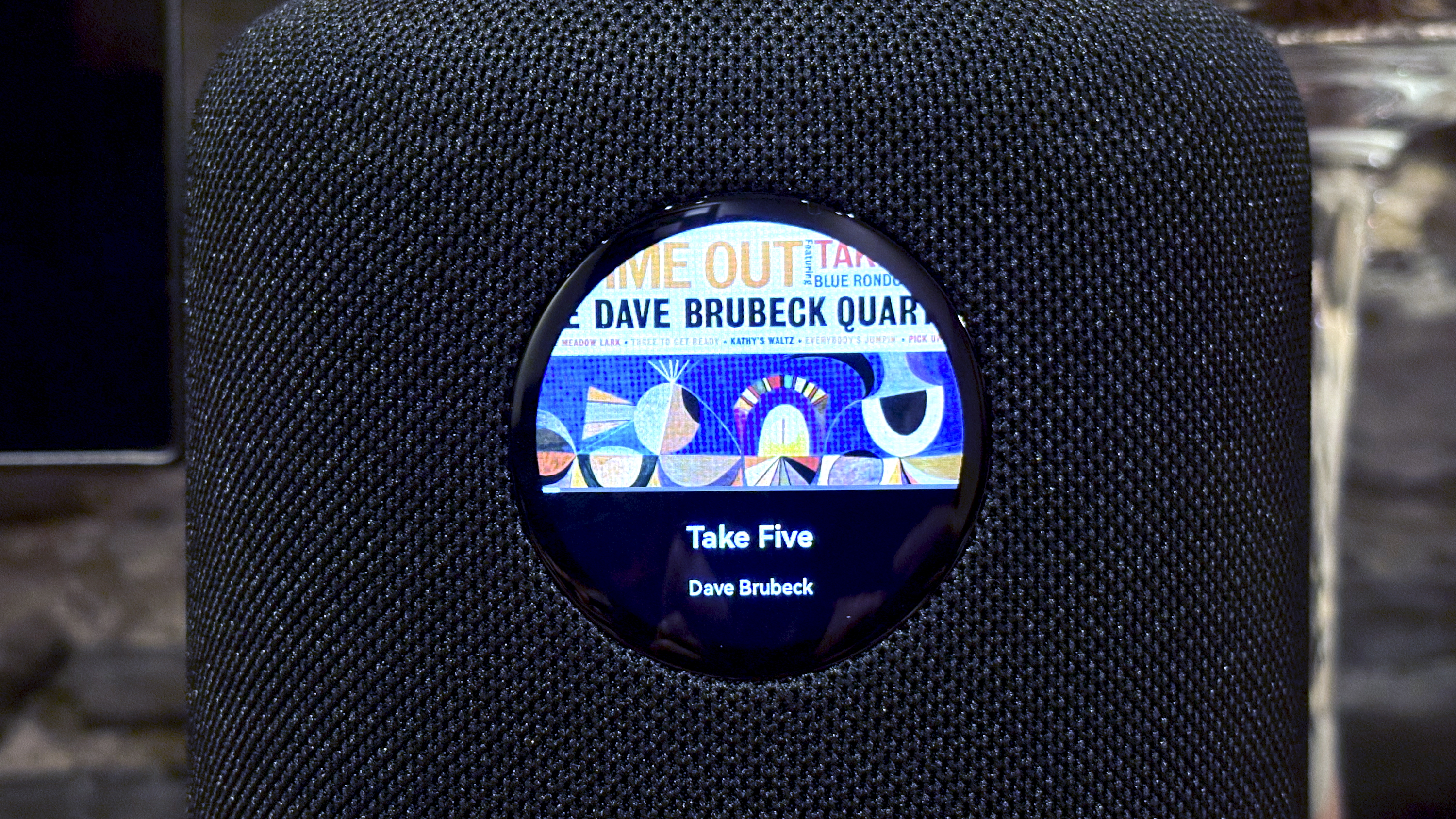 The WiiM Sound, in a home, on a varnished wooden table, showing the illuminated front panel
