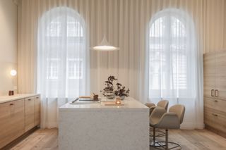 A kitchen with white sheer curtains