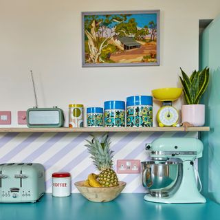 Kitchen with blue worktops and shelving with retro-style appliances