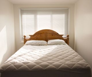 A mattress on a bed against a white wall.