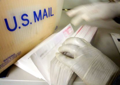 A postal worker sorts mail after an anthrax scare