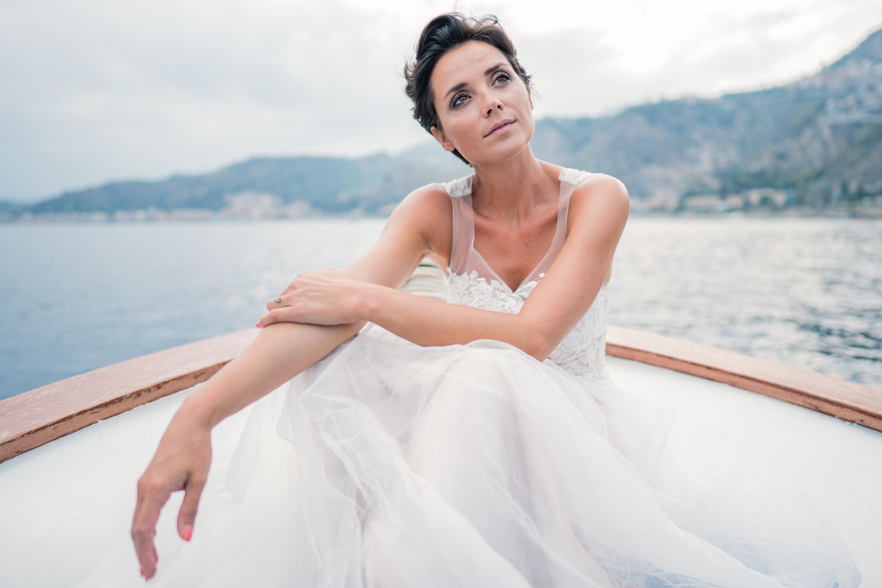 Woman in white dress sitting in a boat