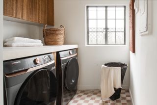 A small laundry room with textured checkered floor tiles