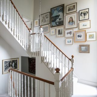 staircase with photoframes on white walls