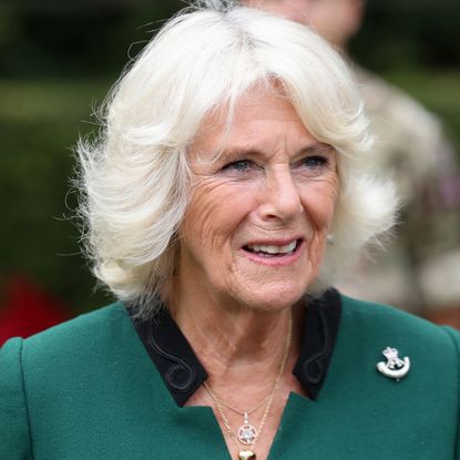 Queen Camilla wearing a green coat