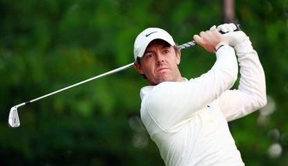 Rory McIlroy strikes his iron shot and watches the flight