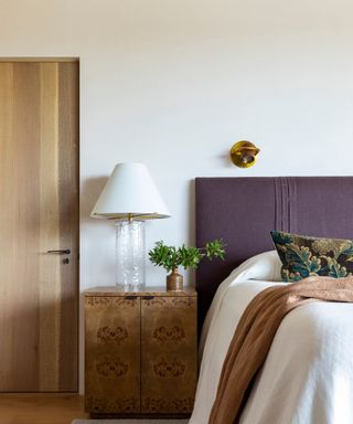 Neutral bedroom with purple headboard