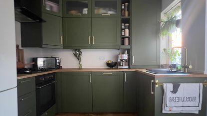 green kitchen with wood floor and wood worktops