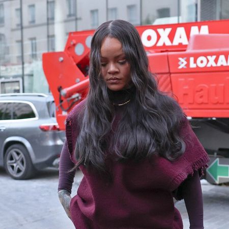 Rihanna wearing a burgundy shirt, cargo pants, and pointed-toe shoes