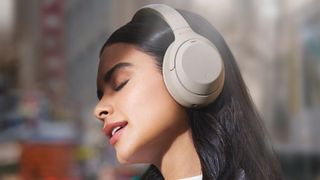 a woman closing her eyes while wearing the sony wh-1000xm4 which are the best wireless headphones of 2021