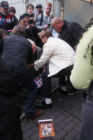 Ryan Gosling helps up a fan after a barrier falls as he arrives at BFI Southbank for an 'In Conversation about Barbie' event on December 08, 2023 in London, England. (Photo by Neil Mockford/GC Images)