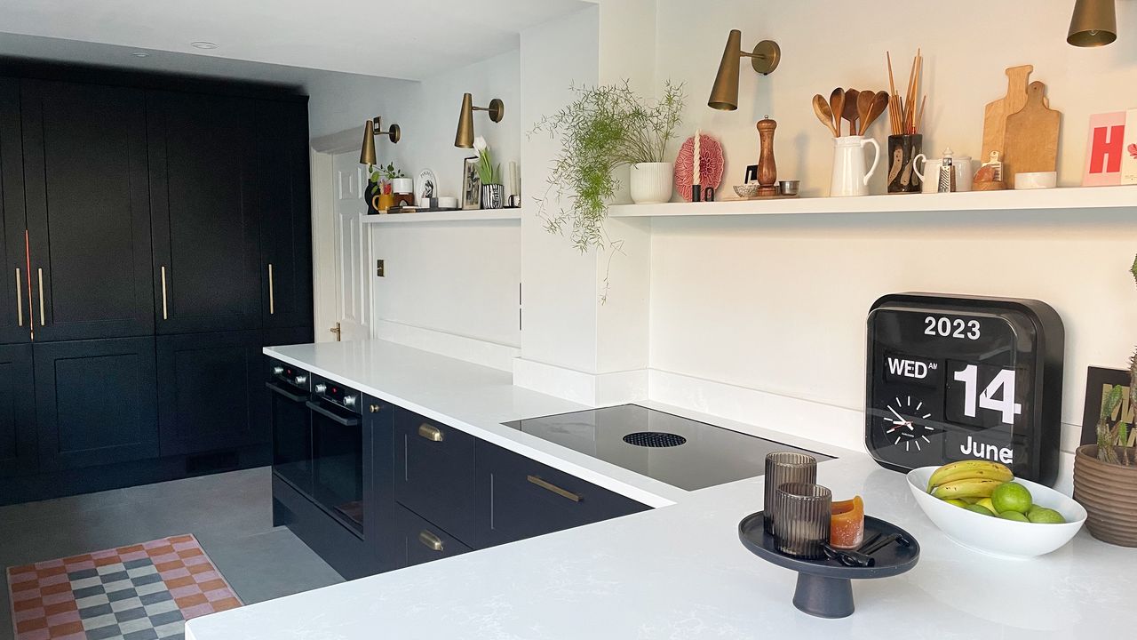 Dark grey kitchen with white worktops and an open shelf instead of wall cabinets