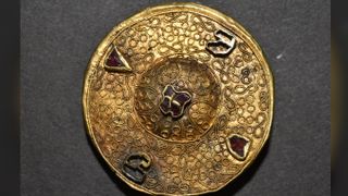 This gold brooch was found buried next to a woman who was buried not far from the rider with headless horse. The relationship between this woman and the rider is not clear.