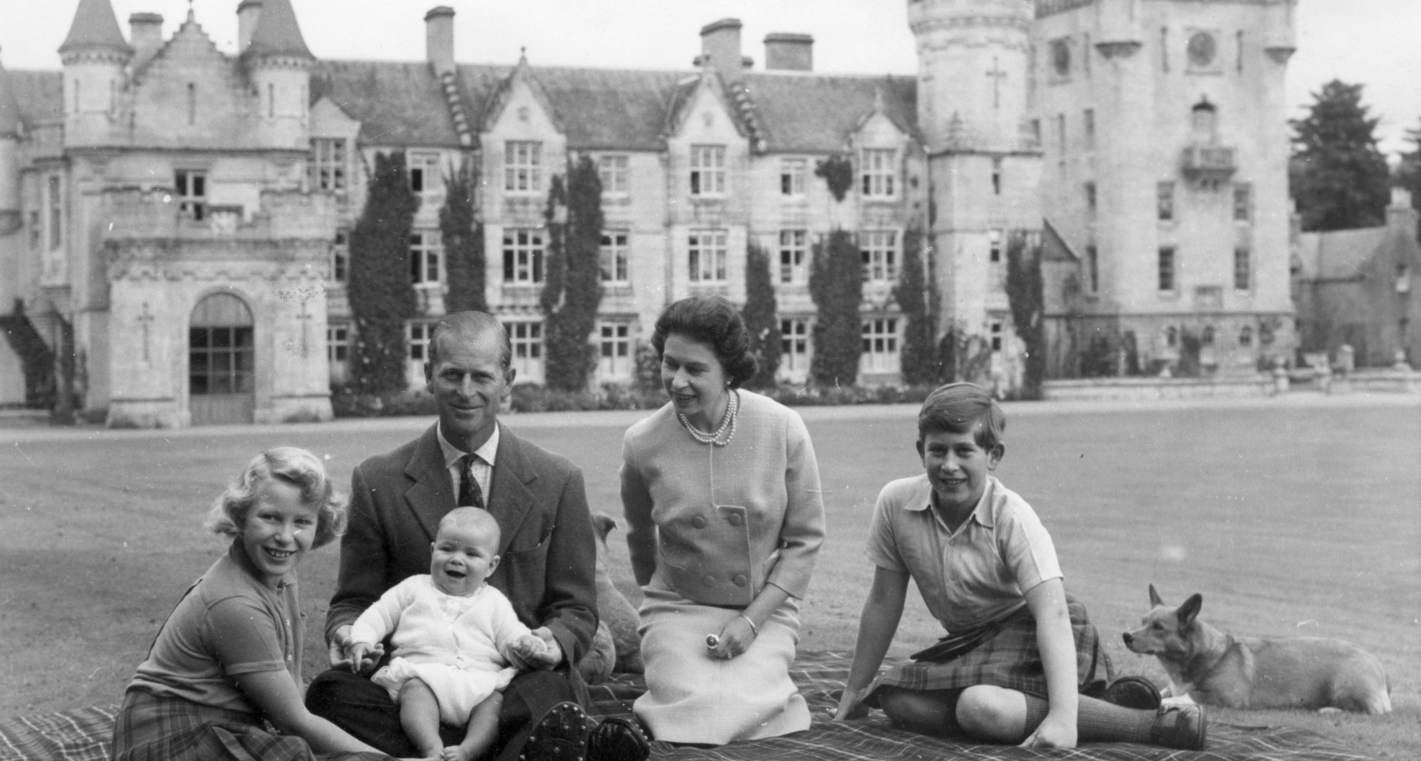 Queen Elizabeth sitting on a picnic blanket with Prince Philip and their kids at Balmoral Castle