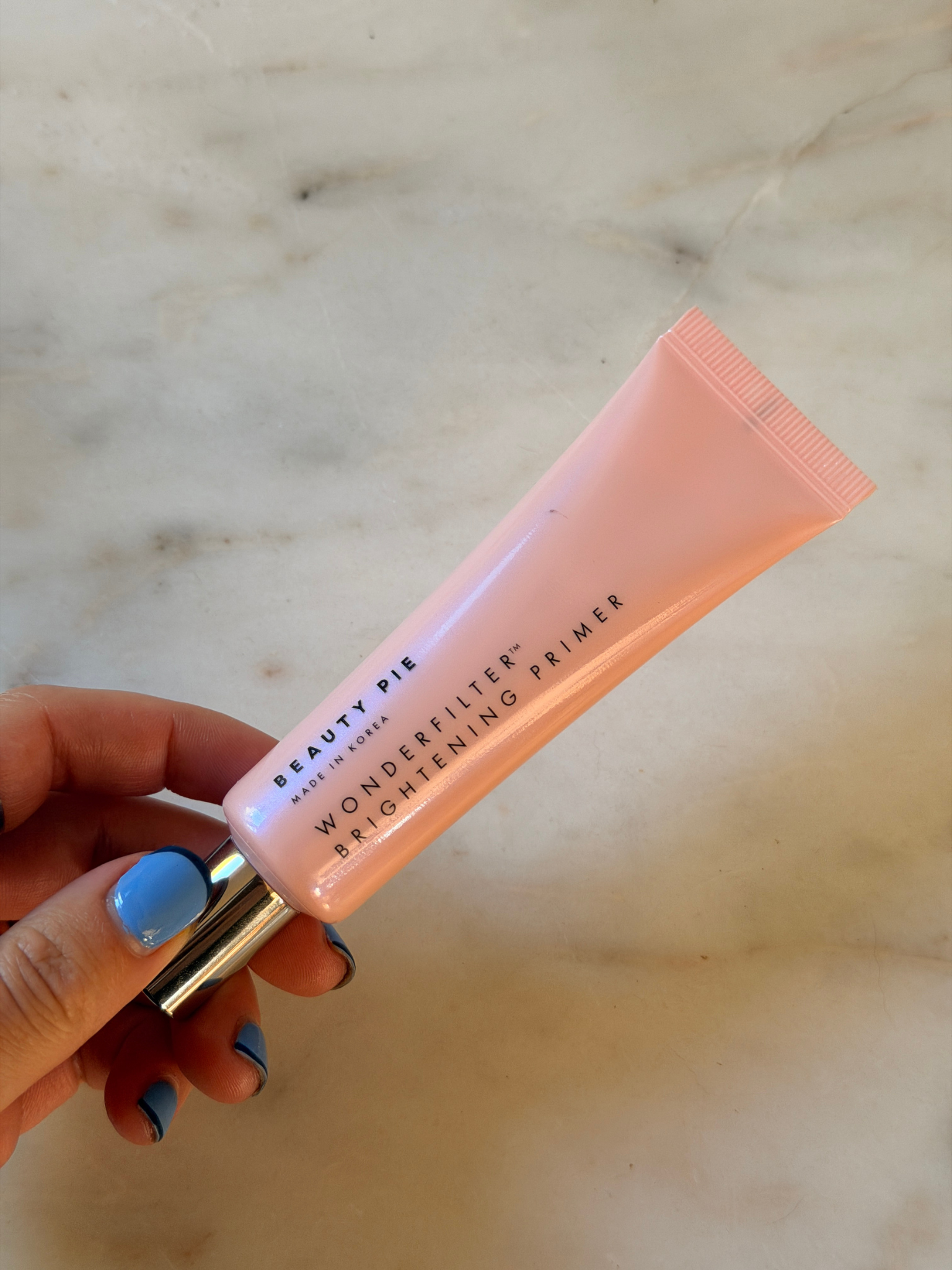 Freelance beauty editor Grace Day holding the Beauty Pie primer.