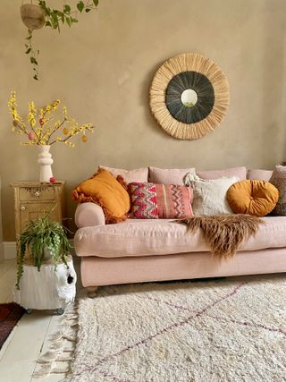 boho living room with easter tree and pink sofa and rattan mirror