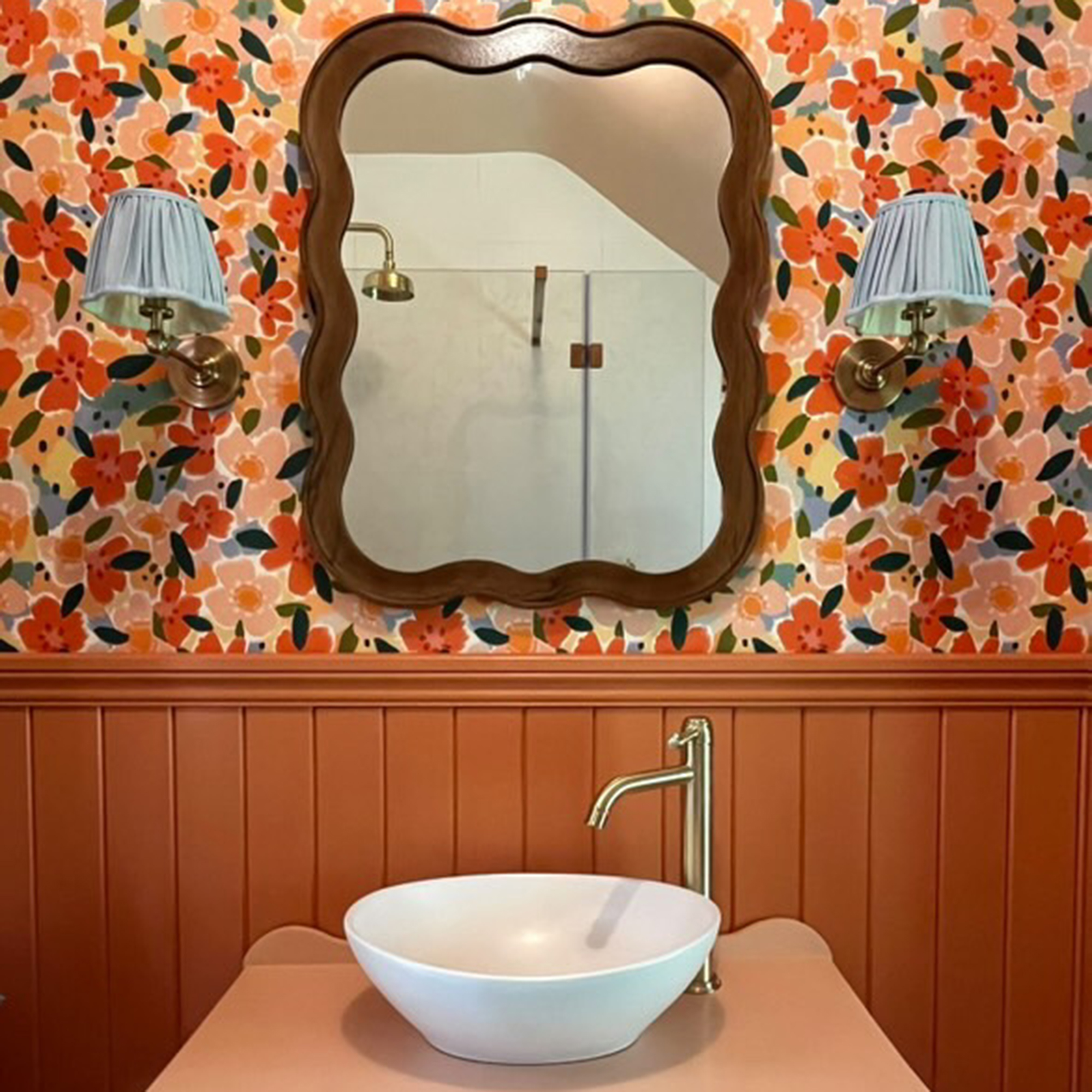 bathroom sink with floral wallpaper on the wall above it