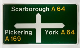 Green and white information road sign to Scarborough