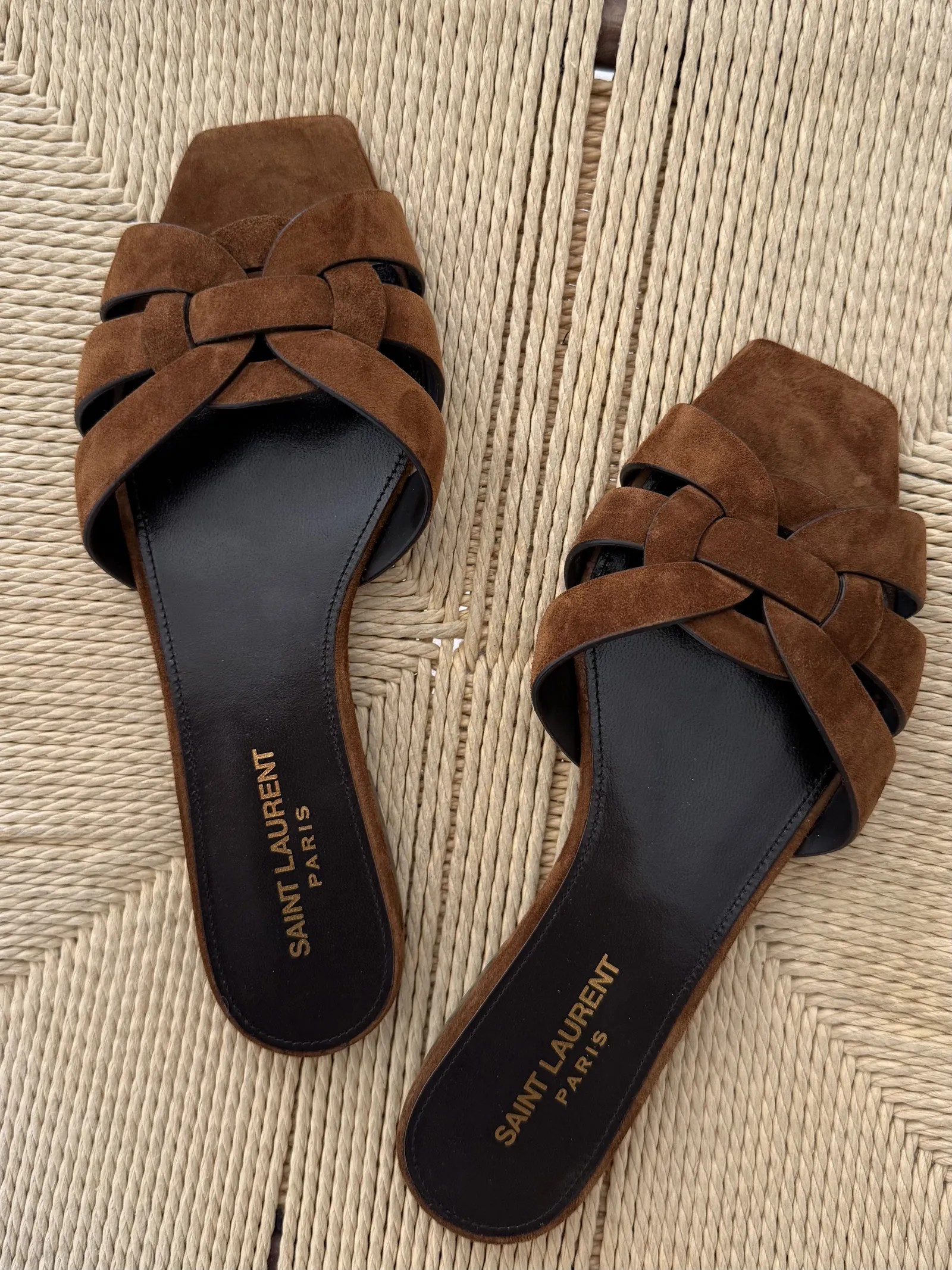 Image of the Saint Laurent Tribute mules sandals suede version on a chair.