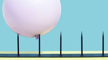 pink balloon bouncing along row of metal spikes