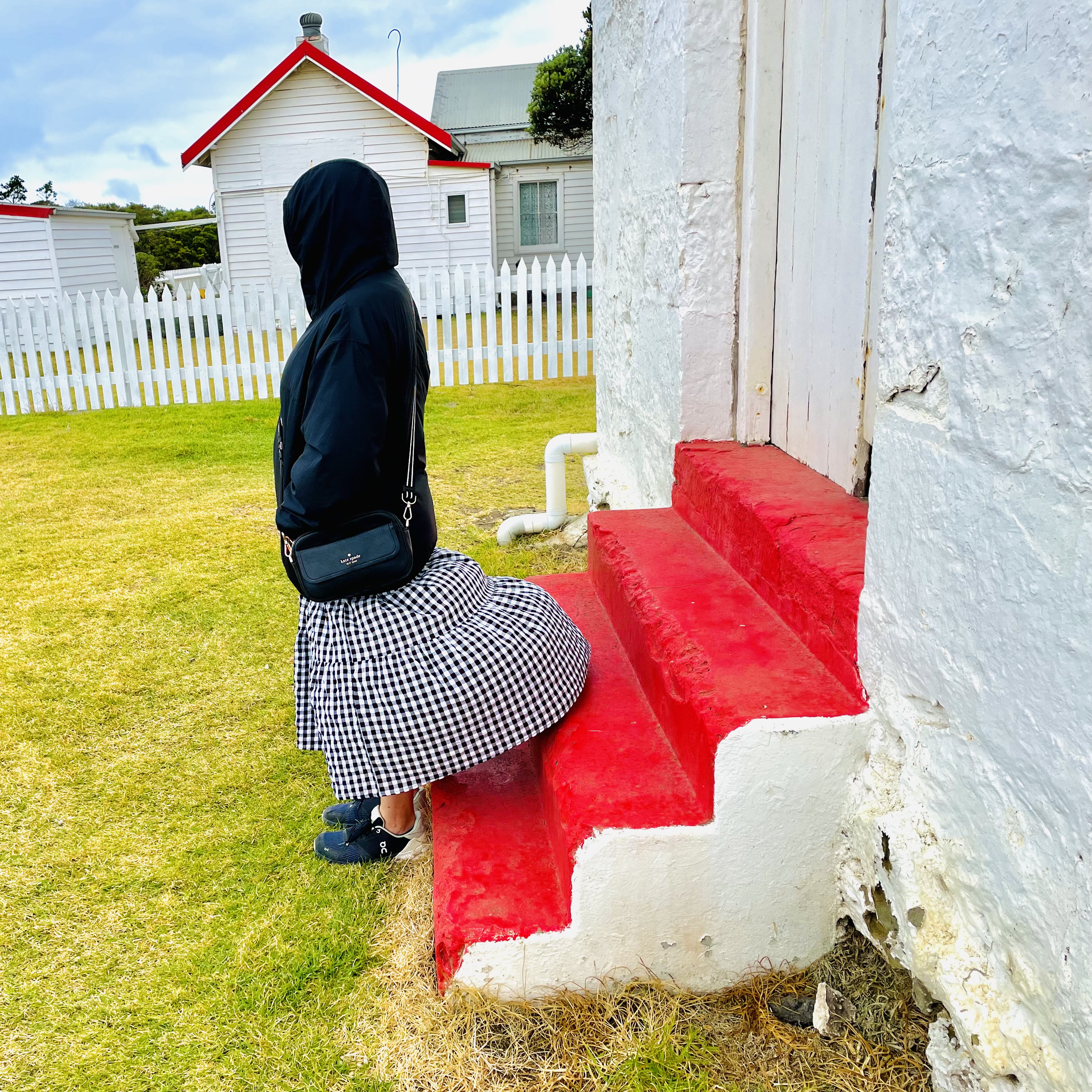 A girl in a hoody standing in front of some red steps