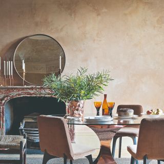 A dining room with a round table and limewashed walls