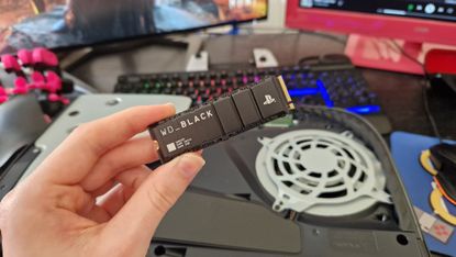 WD Black SN850P held in front of an open PS5