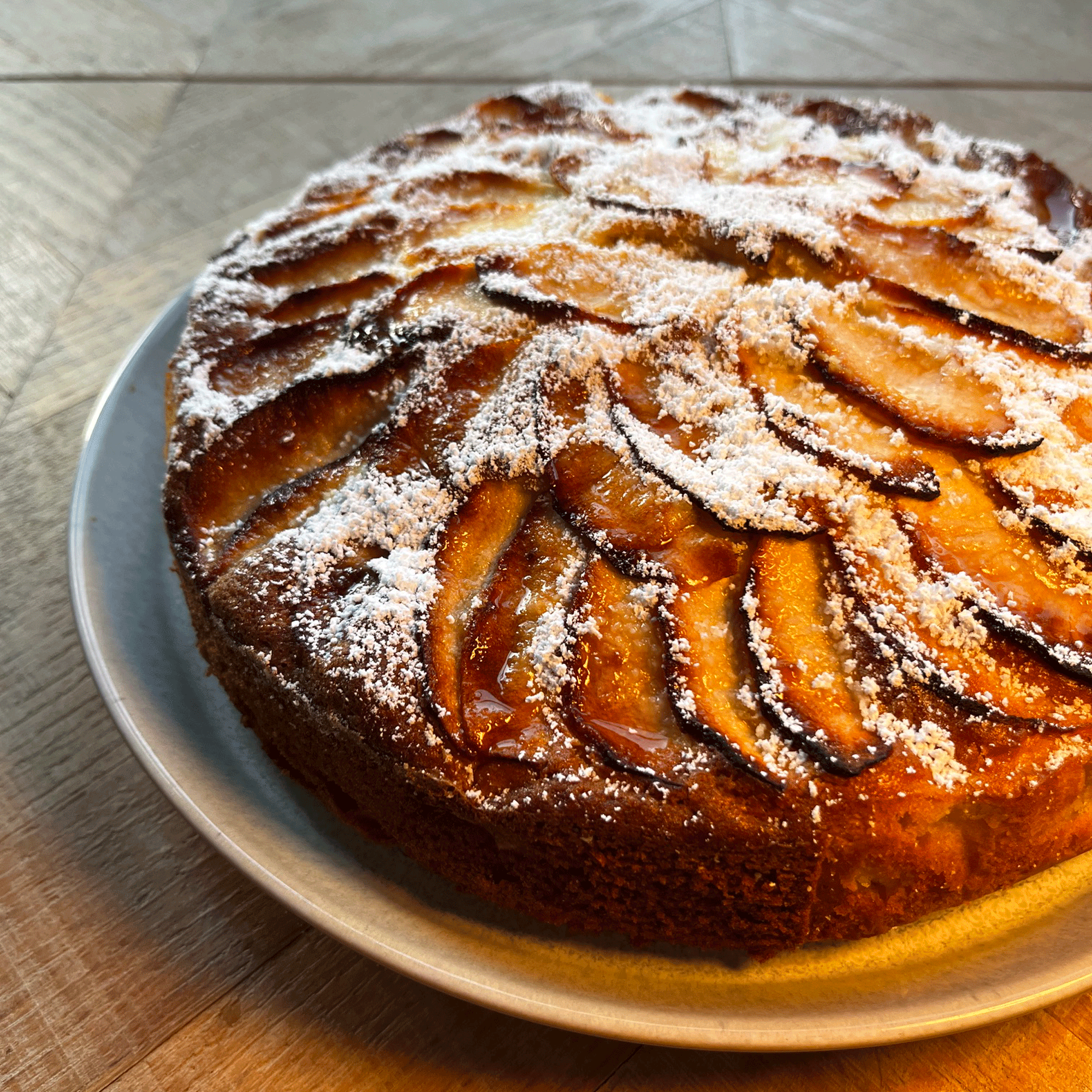 an baked apple cake on a plate on a wooden surface