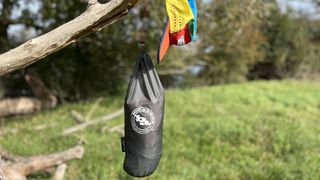 A bivy in its sack, hanging from a tree branch