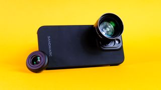 A photo of a Sandmarc iPhone lens attached to an iPhone 15 Pro using the Sandmarc iPhone case, all against a yellow background