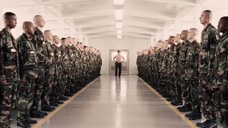 A sergeant stands in the middle of two long lines of military trainees in Jarhead