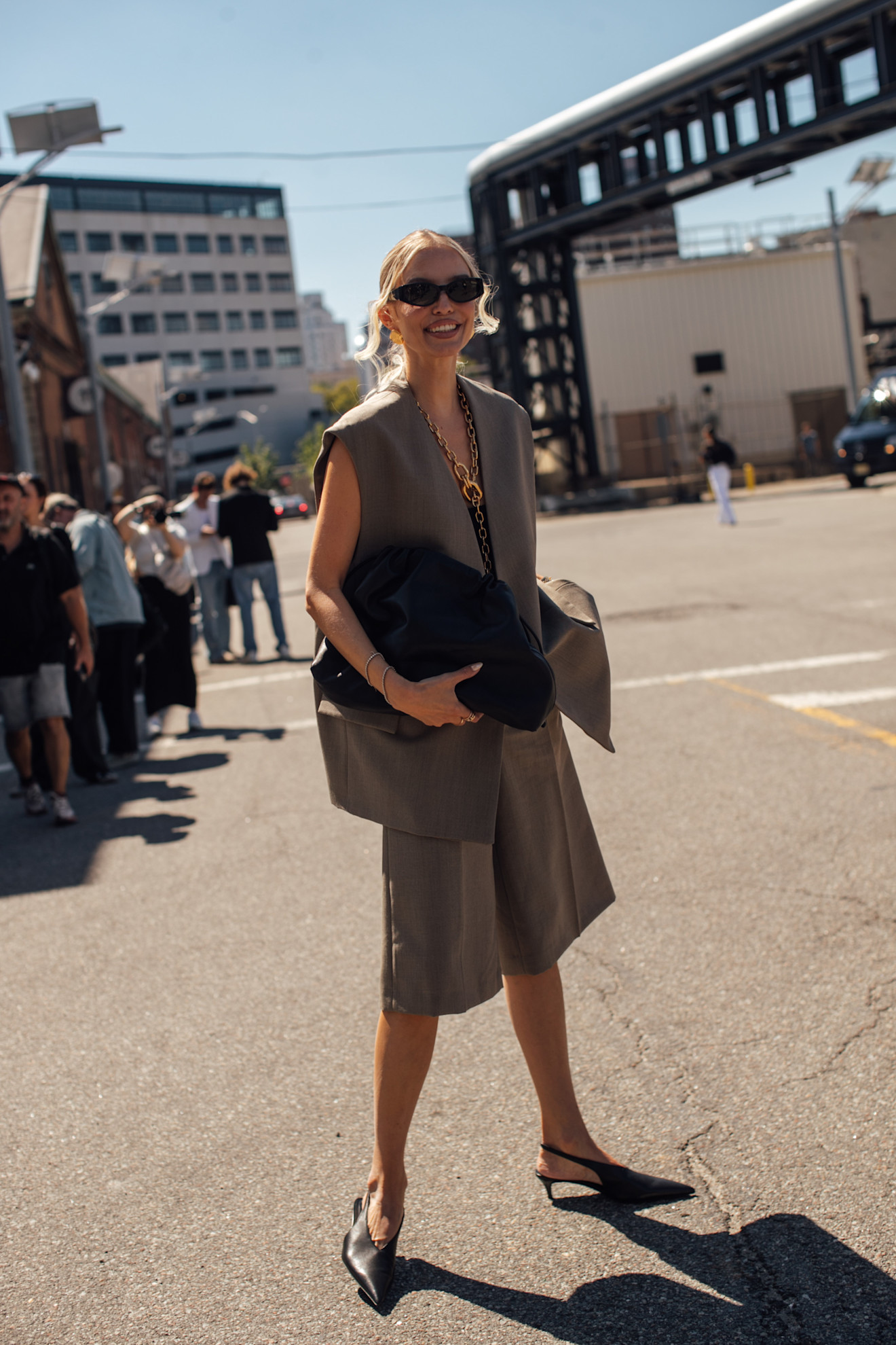 woman wearing tailored vest, bermuda shorts, and heels